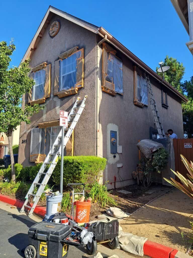 Painting house exterior during home renovation process.